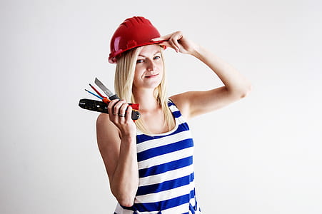 woman wearing blue and white striped tank top and red safety hat