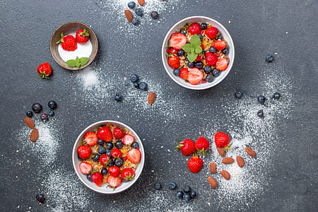 three round white bowls filled with strawberries
