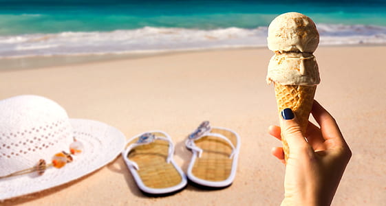person holding ice cream in beach
