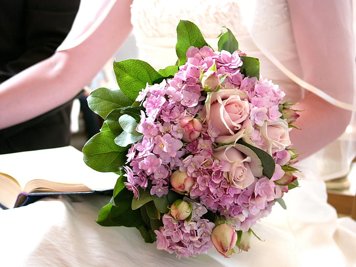 woman holding pink and purple petaled flowers bouquet