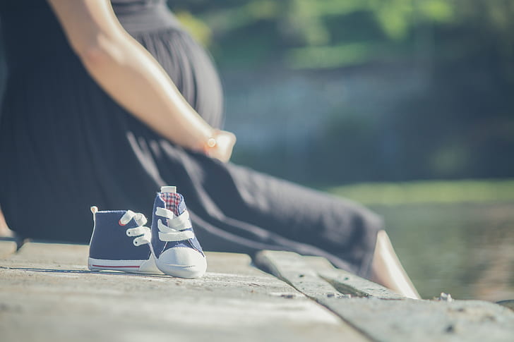 Pregnant woman and man baby shoes. Selective focus. nature Stock Photo -  Alamy