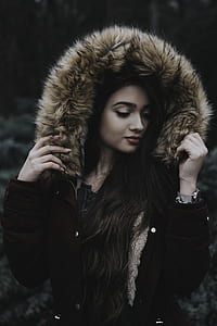black haired woman wearing brown parka jacket