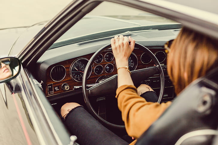 brown haired woman sitting inside car while holding steering wheel