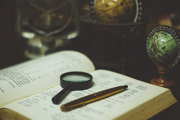 black magnifying glass on white book