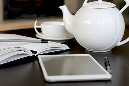photo of white tablet with stylus pen near teapot