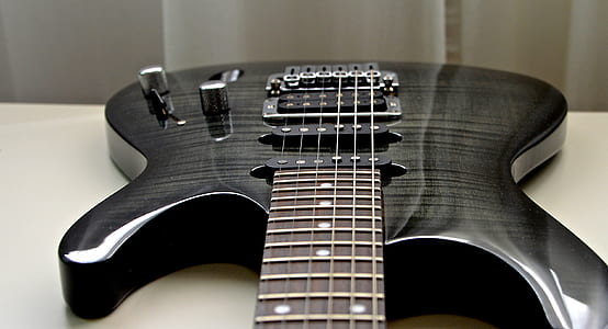 closeup photo of black and gray double cutaway electric guitar