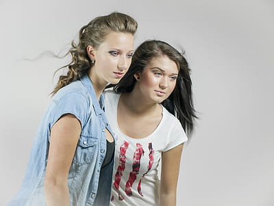 two woman wearing white shirt and blue denim button-up shirt