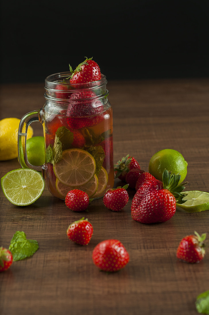 sliced lemon and strawberries on clear mason jar