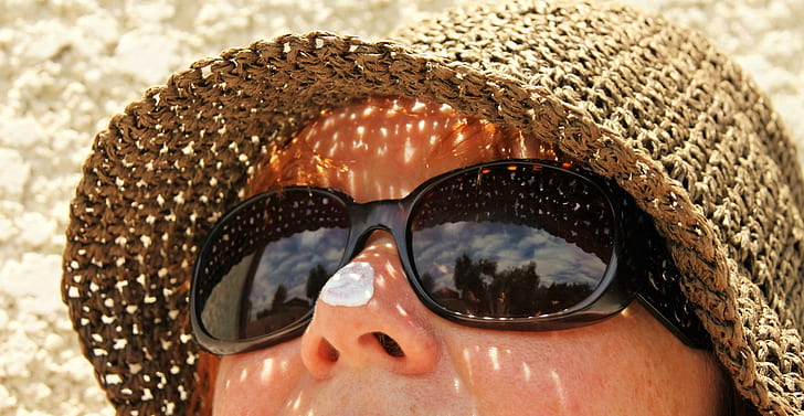 woman wearing black sunglasses and brown hat
