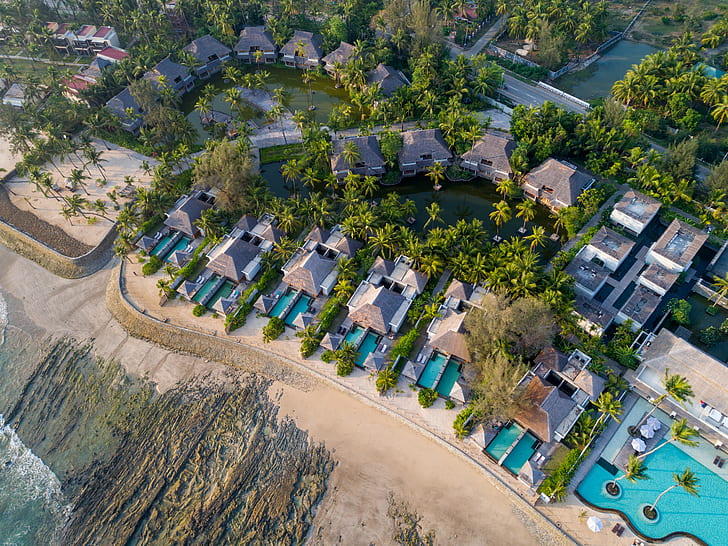 bird's eye view of resort houses and swimming pools surrounded by trees during daytime