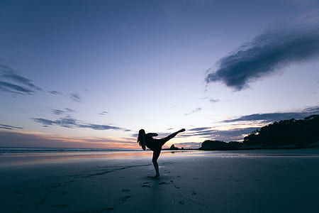 woman doing martial art beside ocean