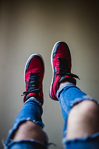 shallow focus photography of person wearing black-and-red shoes