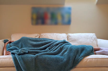 person lying on sofa covering body