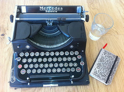 blue and black Mercedes typewriter on brown wooden table