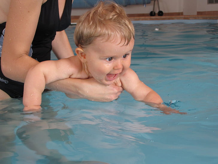 woman carrying baby about to swim
