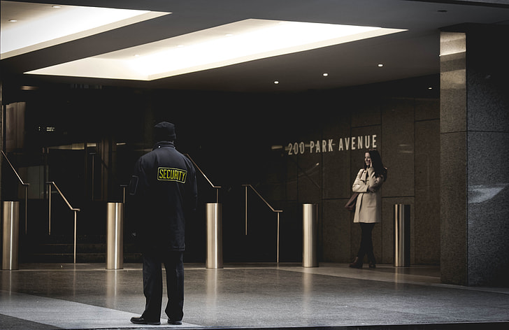 woman and security guard standing inside hall