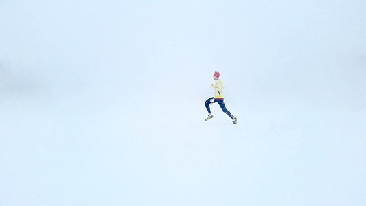 person in yellow sweater and blue pants leaping on air