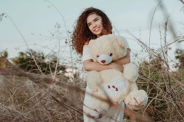 woman carrying yellow and white bear plush toy