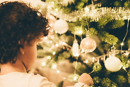 girl facing Christmas tree with baubles