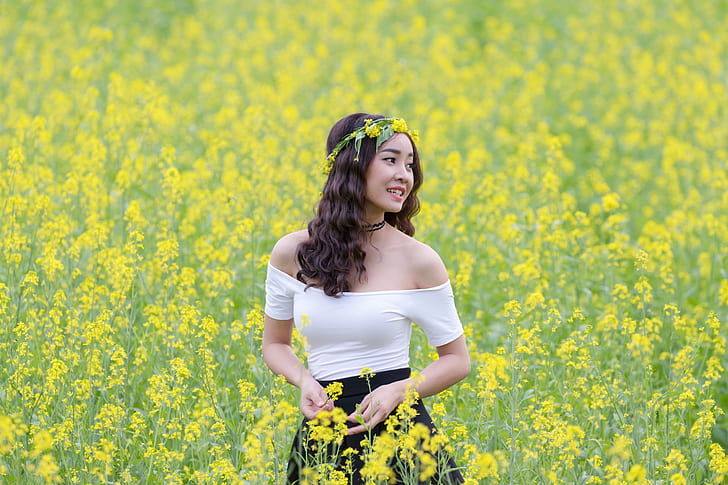 selective focus portrait photograph of woman wearing white off-shoulder dress on a bed of yellow petaled flowers