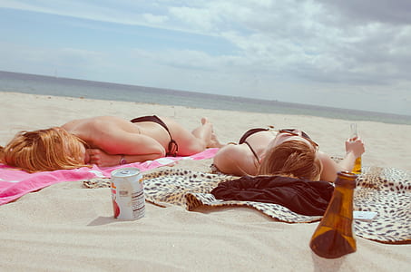 two women lying on sand