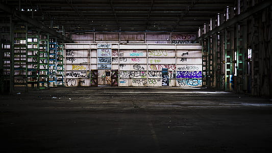 gray metal shelving unit empty with graffiti
