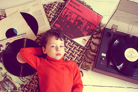 boy's laying on black vinyl record