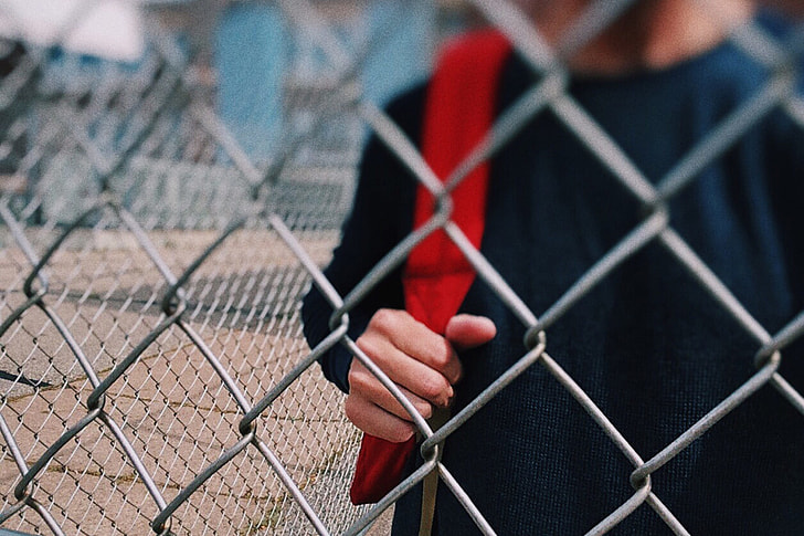 Child by fence in school playground