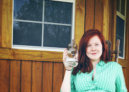 Woman in Green Button Up Collared Shirt Holding Clear Glass