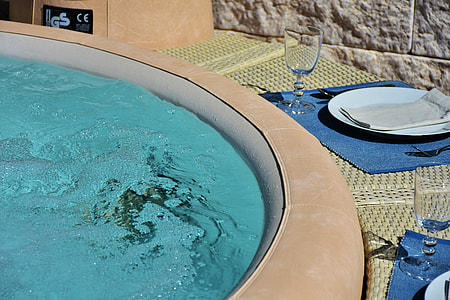 round white plate and clear long-stemmed wine glass beside above ground pool