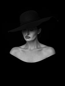 greyscale photo of woman wearing off-shoulder top and hat