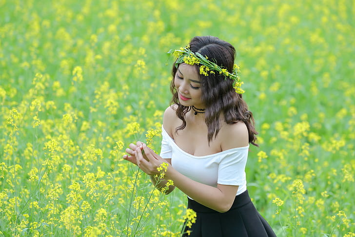 woman in white and black dress standing in flower field