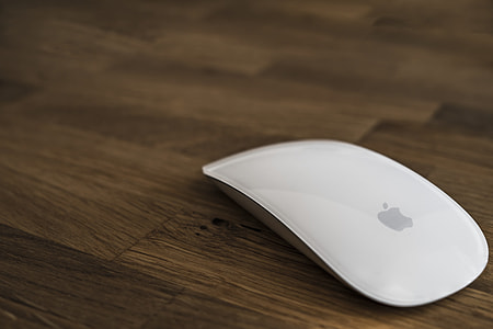 Apple Magic Mouse on brown wooden surface