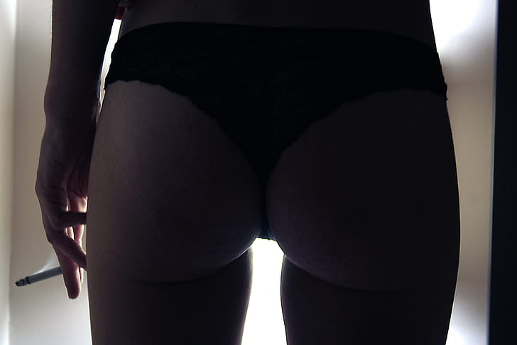 woman wearing black thong taken on low lit room