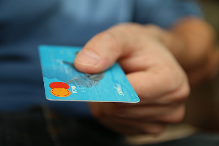 person holding blue MasterCard credit card