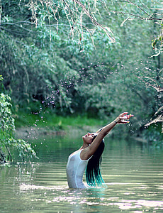 photography of woman stretching her hands while in the body of water