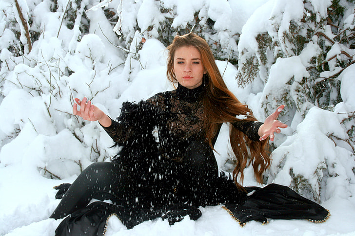 woman wearing black long-sleeved dress on top of snowfield