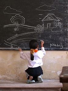 girl draw a house on chalkboard