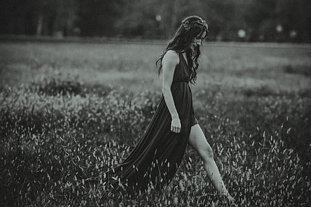 A woman in a dress walks in a field