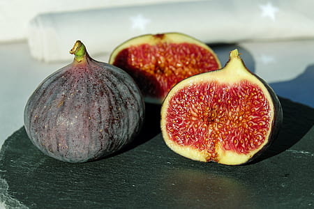 three fig fruits on brown surface