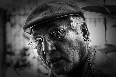 grayscale photography of man in beret and eyeglasses