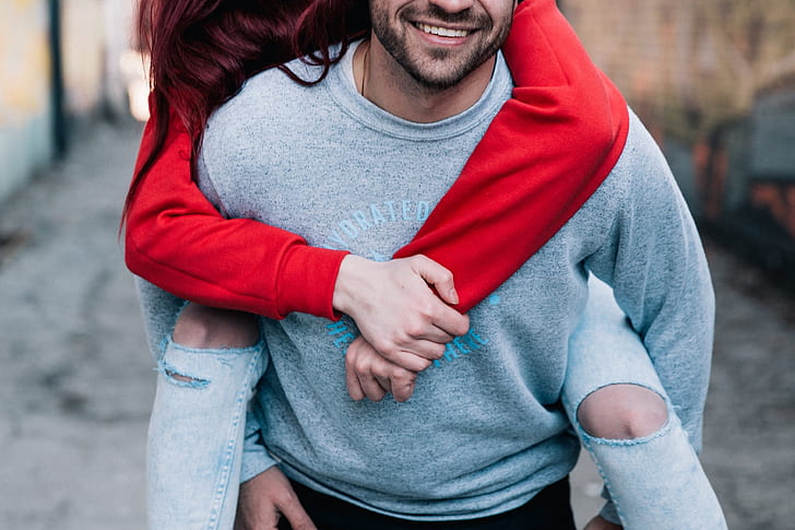 man wearing grey sweater with woman wearing red sweater