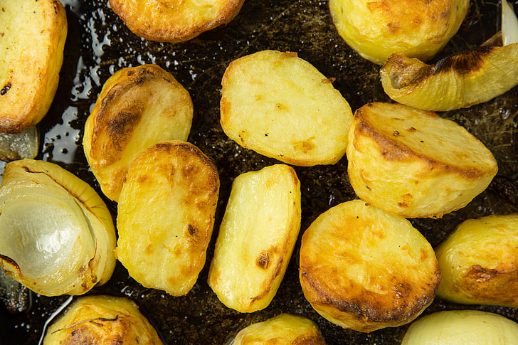 Roast potatoes and onions in baking tray