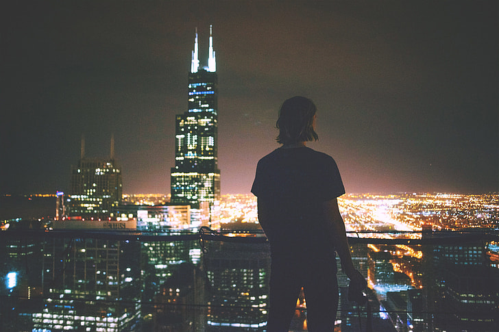 A man enjoying the view across the city at night