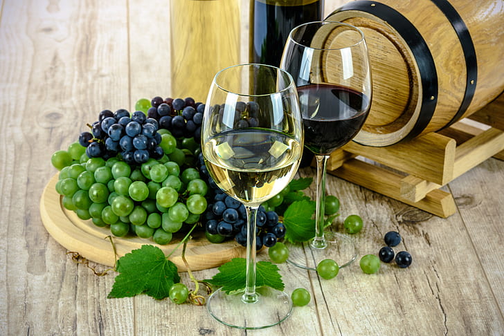 two wine glass beside grapes