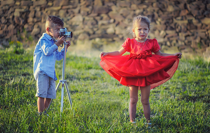 boy taking a photo of a girl wearing red dress