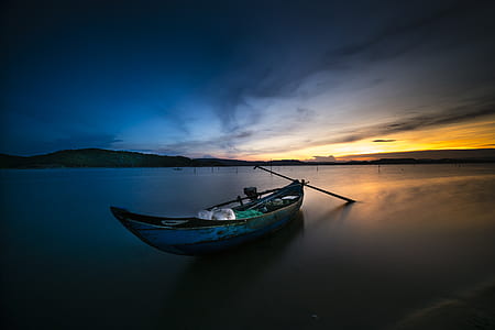 photo of canoe on body of water during golden hour