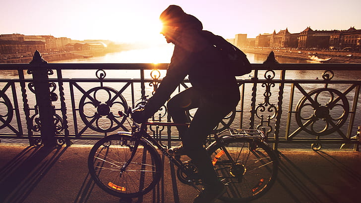 silhouette photo of person riding on bicycle