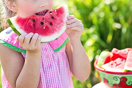 girl holding watermelon during daytime