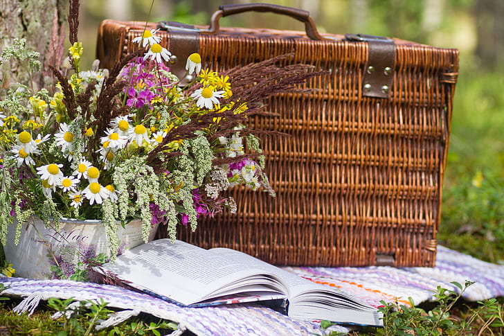 brown woven picnic basket beside book